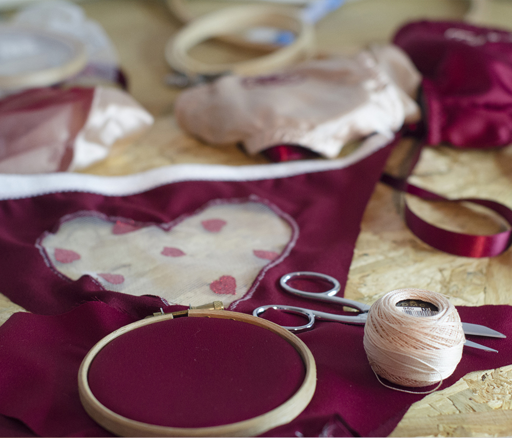 culotte bordeaux à plat avec un tambour à broderie des ciseaux et du fil