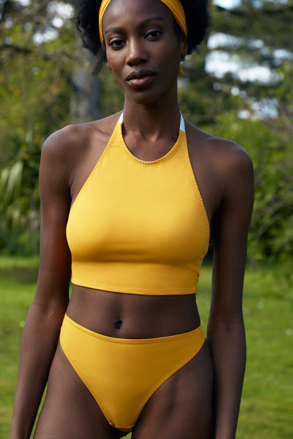 femme debout portant un crop top jaune