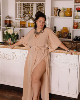 Femme portant une robe tunique oversize beige dans un restaurant en bordure de plage en sortir de bain