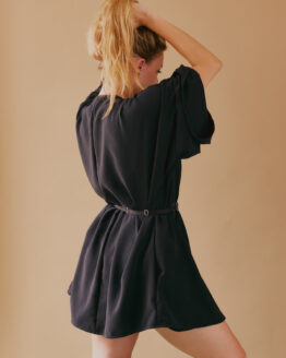 Femme debout de dos, se tenant les cheveux portant une robe kimono courtes manches longues noire ceinturée à la taille