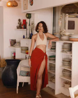 Femme portant un paréo de plage terracotta dans un restaurant en bordure de plage